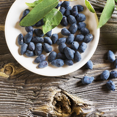 Berries ripe garden honeysuckle on a dark wooden background