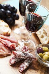 Red wine with appetizer assortment on the background
