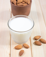 Almond milk with almond on a wooden table.