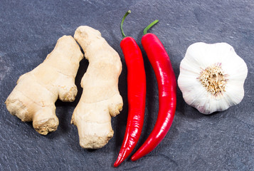 Chili peppers, garlic and ginger on a black background