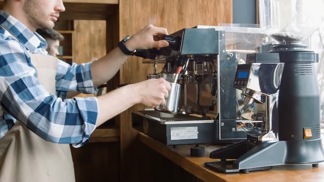 Pleasant handsome barista making coffee