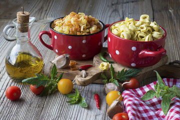 Still life Italian pasta. Tortellini in the form of hearts on a cutting board with olive tree