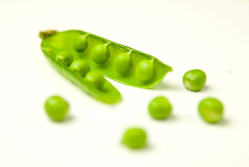 Pea pod and pea seeds on white