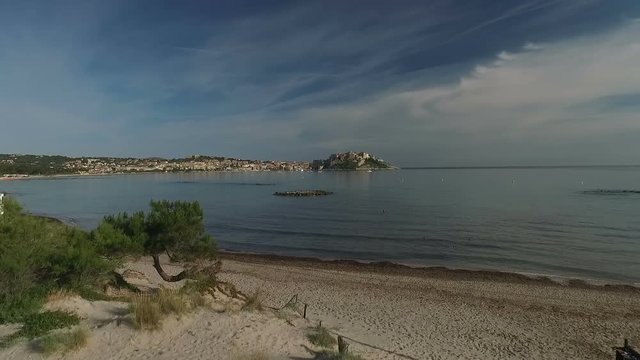Aerial: Flight over historical citadel of Calvi, beautiful city on Corsica island, France, Europe 