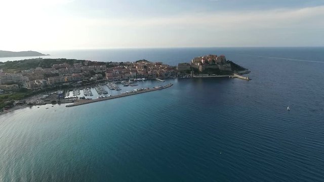 Aerial: Flight over historical citadel of Calvi, beautiful city on Corsica island, France, Europe 