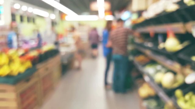 People are shopping in a supermarket, defocused background blur