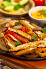 Chicken Fajitas with Grilled Onions and Bell Peppers serve with Tortillas. Selective focus.