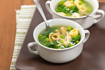 Tortellini Soup with Peas and Spinach. Selective focus.