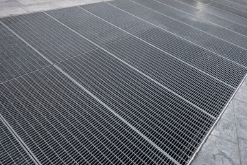 Griglie metalliche di aerazione condominiali collocate sul marciapiede