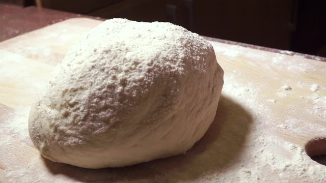 Man hands kneadding dough on wooden cutting board