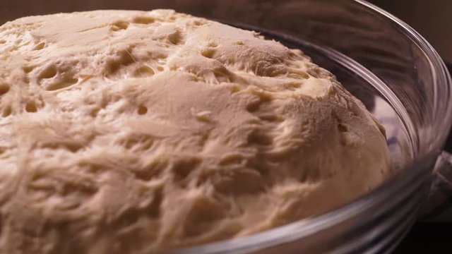 Yeast dough raising in a glass bowl, time lapse video