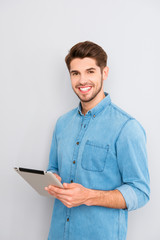 Happy handsome young man holding digital tablet