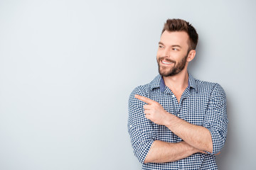 Cheerful handsome man showing direction and pointing with finger