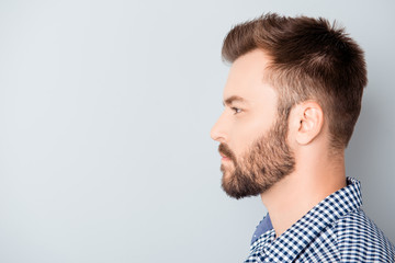 Side view of young bearded man isolated on gray background