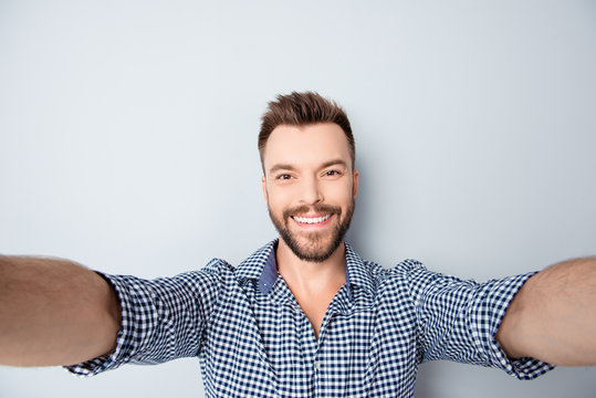 Cheerful handsome bearded young man making selfie