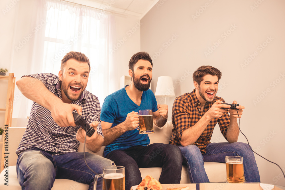 Poster photo of happy cheerful men resting and play video game with joy