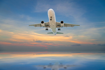 Fototapeta na wymiar Airplane flying tropical sea at sunset time.