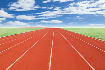Running track with green grass and blue sky white cloud backgrou