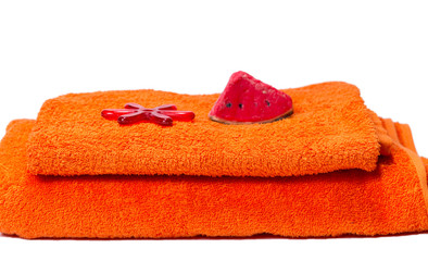 Soap and starfish on a stack of red bath towels