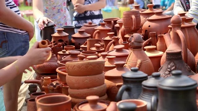 Selling of pottery in the retail store outdoors, buyers choose goods
