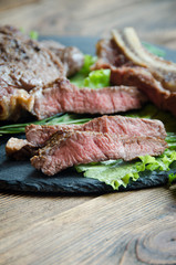 grilled steak black plate wooden table