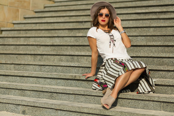 Obraz premium Beautiful boho girl sitting on the stairs