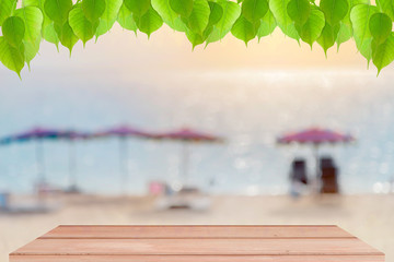 Wood floor with Green leaves frame on blur beach background,scen
