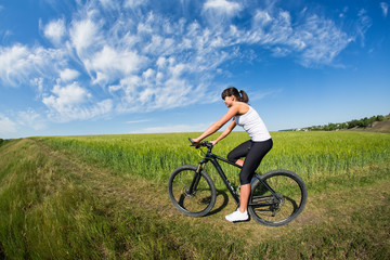 woman going for bike ride on sunny day in countryside