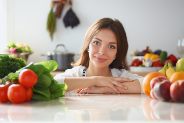 Young woman standing near desk in the kitchen