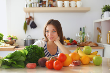 Young woman standing near desk in the kitchen