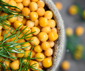 peas sprinkled with dill in a linen sack on grey background