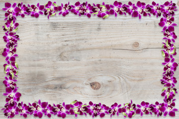 Beautiful orchid flower frame on wood texture background.