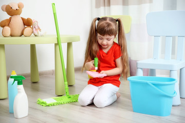 Cute little girl cleaning her room