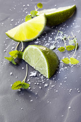 Lime Wedges with Sea Salt and Micro Herbs over Slate