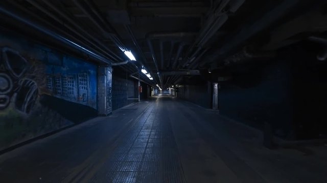 Smooth camera steady slide shot around old long extended industrial house tunnel basement, with grudge walls, rusty ripes, metal flour and broken lamps, perfect for cinema or movie clips background