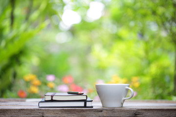 Notebook with pencil and cup on wooden table