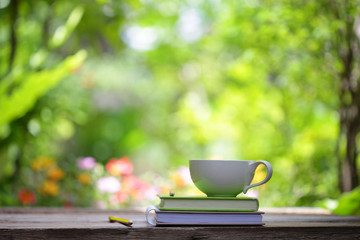 Notebook with pencil and cup on wooden table