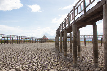 perspective wooden bridge with dry earth and cracked ground texture, broken split land with soil background