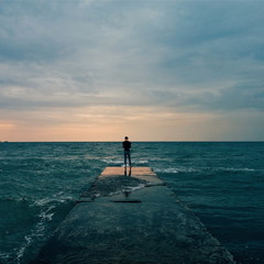 Man stands on the edge of a pier