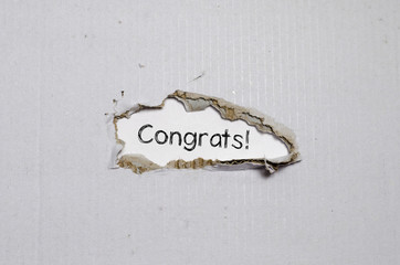 The word congrats appearing behind torn paper.