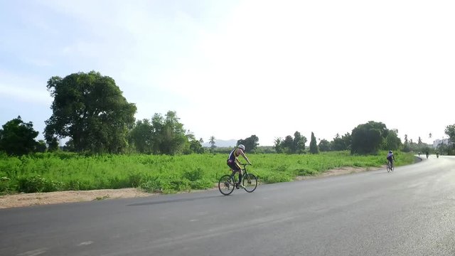 A man riding a bicycle in a clear sky in thailand