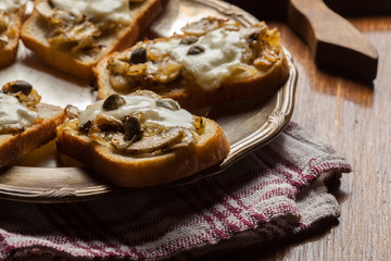 Crostini with fried mushrooms, onion and mozzarella cheese