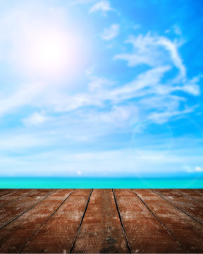 Beautiful Beach With Wooden Plank On Blue Sky With The Sun Background.