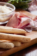 Italian grissini with ham prosciutto, mozzarella and arugula