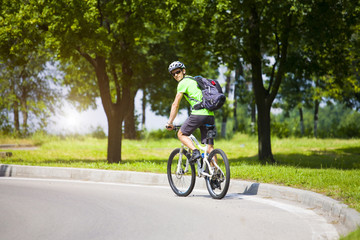 Fototapeta na wymiar A man on a Bicycle with a backpack.