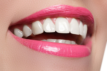 Macro happy woman's smile with healthy white teeth, bright pink .lips make-up. Stomatology and beauty care. Woman smiling with great teeth. Cheerful female smile with fresh clear skin

