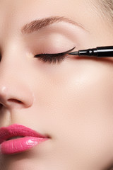 Beautiful woman with bright make up eye with sexy black liner makeup. Fashion arrow shape. Chic...