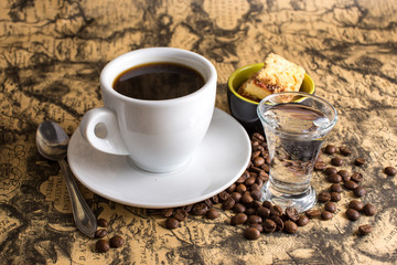 cup of hot espresso coffee, and cookie on a map