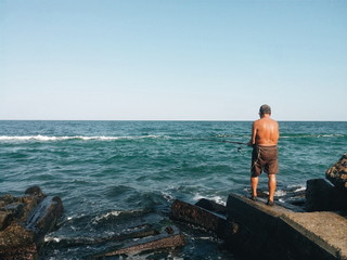 Man fishing on the sea coast