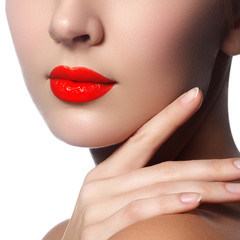 Obraz na płótnie Canvas Close-up shot of woman lips with glossy red lipstick